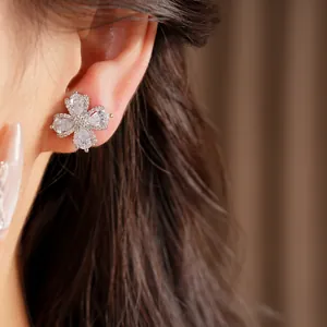 Detailed view of elegant zircon flower clip-on earrings on a model's ear