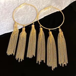 Close-up detail view of gold hoop earrings featuring elegant long chain tassels design