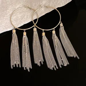 Close-up of elegant silver hoop earrings with long chain tassel details.