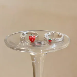 Dettaglio di dolci anelli aperti fragola in argento con pizzo su base di vetro