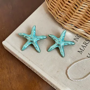 Gros plan détaillé de pendentifs étoile de mer en métal turquoise avec finition émaillée