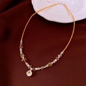 Elegant vintage beaded necklace featuring a sparkling crystal pendant on dark brown fabric