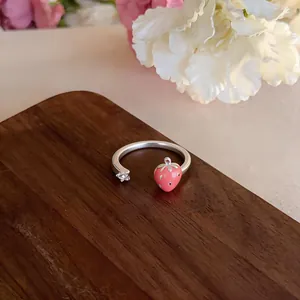 Dettaglio di un anello aperto in argento con fragola in smalto rosa e charm stella
