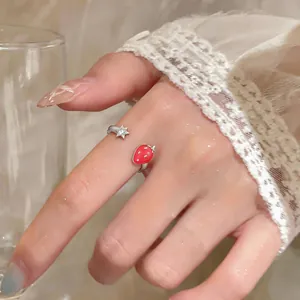 Primo piano di un anello regolabile con fragola smaltata rossa e dettaglio stella