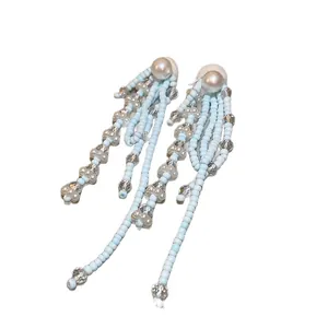 Hellblaue Quastenohrringe mit Perlen, eleganter Schmuck für den Sommerurlaub am Meer.