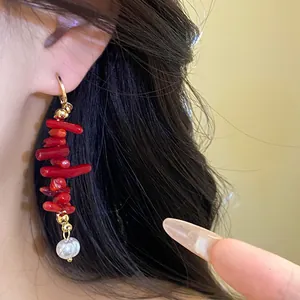 Close-up of vintage red resin and pearl tassel drop earrings on model's ear