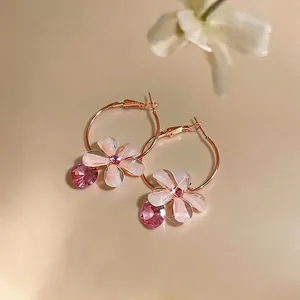 Elegant rose gold hoop earrings featuring pink resin flower and sparkling crystal charms