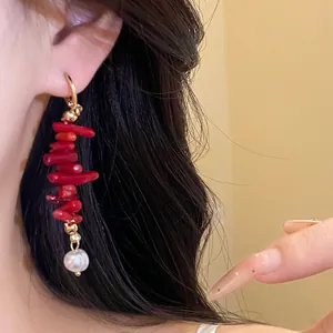 Detailed close-up of vintage red resin tassel hoop earrings with pearl drop on Asian model