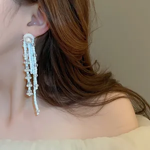 Detailansicht eleganter Perlenohrringe mit weißen Perlen und blauen Perlen für den Urlaub