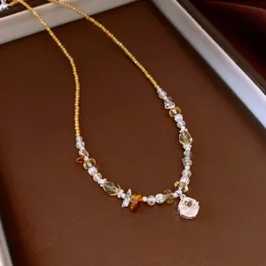 Detailed view of a vintage beaded necklace with yellow crystals and a flower pendant