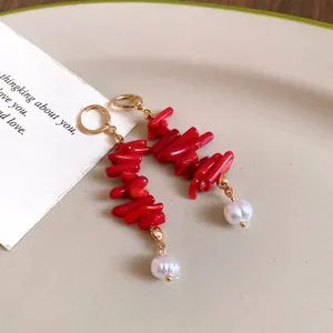 Detail view of retro red resin beads and pearl tassel earrings on a ceramic plate