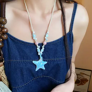 Detail of a handmade ceramic starfish pendant on a beaded dopamine necklace.