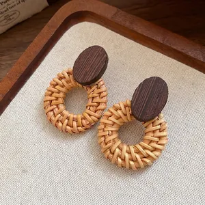 Vintage ethnic style wooden stud earrings featuring hand-woven rattan circles on linen tray