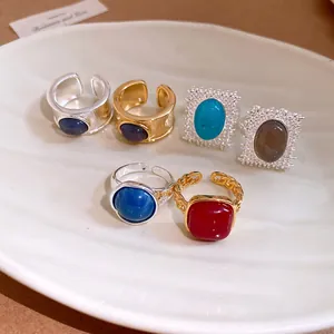 Vue détaillée de bagues vintage avec pierres colorées sur une assiette blanche