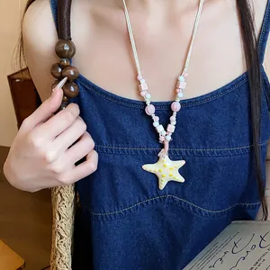 Detailed view of a colorful dopamine ceramic starfish beaded necklace on a model.