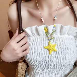 Close-up detail of a yellow ceramic starfish beaded necklace worn by an Asian model
