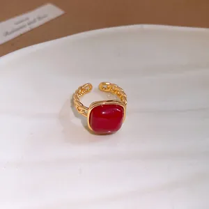 Détail macro d'une bague à maillons en or de luxe avec une pierre rouge carrée éclatante