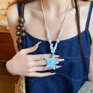 Detailed close-up of a vibrant blue ceramic starfish pendant necklace with beads