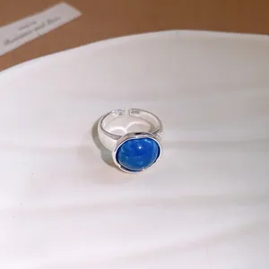 Gros plan d'une bague réglable en argent avec un détail de pierre bleue ronde