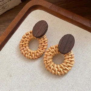 Macro detail of retro handmade woven rattan round earrings with dark wood oval studs