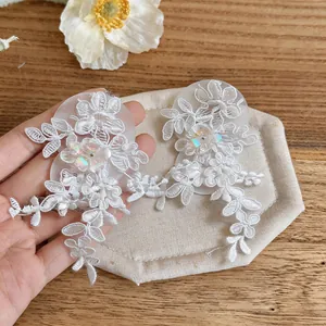Detailed view of white floral lace tassel earrings with iridescent sequin centers