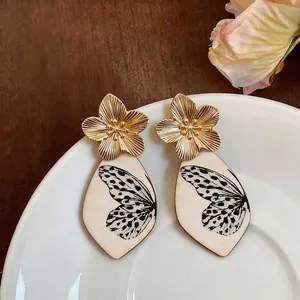 Eleganti orecchini a fiore dorati con pendenti in legno stampati ali di farfalla