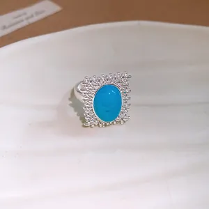 Gros plan détaillé d'une bague vintage en argent avec une grande pierre turquoise ovale