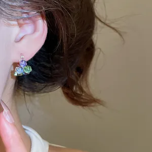 Nahaufnahme eines Mermaid Tears Ohrrings mit lebhaften, bunten quadratischen Steinen.