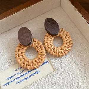Detailed macro view of retro ethnic style handcrafted rattan and wood round dangle earrings