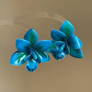 Vue détaillée de boucles d'oreilles orchidées tropicales bleu canard en résine époxy