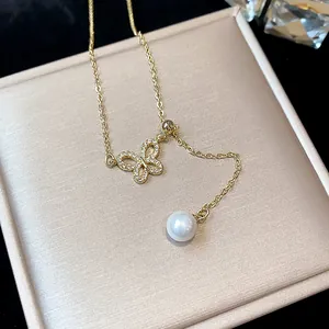 Detailed view of 18k gold plated butterfly necklace with sparkling zircons and a pearl
