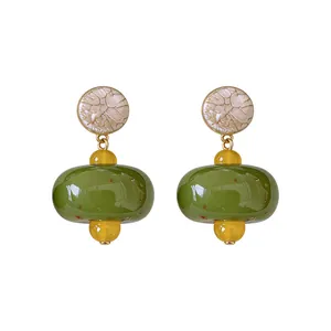 Eleganti orecchini vintage a goccia in resina con perline verde oliva e gialle e perni in argento.