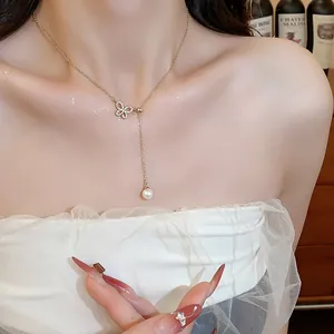 Elegant 18k gold plated butterfly zircon and pearl drop necklace shown on model neck