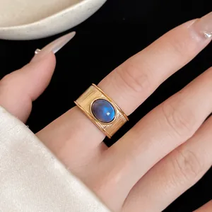 Vue détaillée d'une bague vintage en or avec pierre bleue ovale et bande texturée