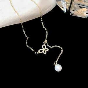 Detailed view of 18k gold plated butterfly necklace with zircon stones and a white pearl drop