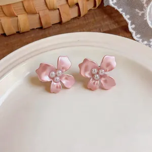 Macro view of elegant pink flower earrings with delicate white pearls in the center