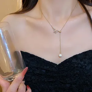 Detailed view of an elegant 18k gold plated butterfly necklace with sparkling zircons and pearl