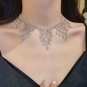 Close-up view of an elegant sparkling rhinestone fringe necklace on a model's neck.