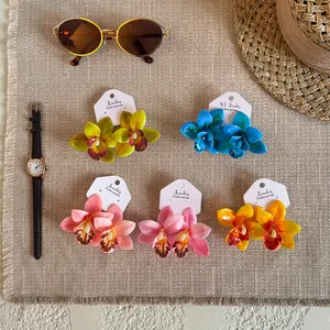 Gros plan de boucles d'oreilles orchidées en résine tropicale en plusieurs couleurs vives