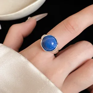 Gros plan d'une bague ouverte en argent ornée d'une pierre cabochon bleue ronde