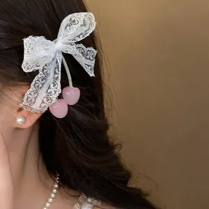 Close-up of elegant lace bow hair clip with pink cherry pendants on model's hair