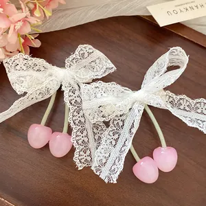 Detailed view of sweet lace bow hair clips featuring cute pink cherry pendants.