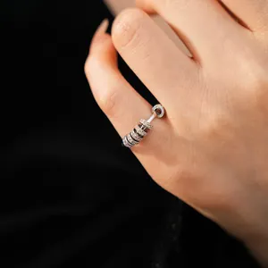Close-up of a minimalist silver ring with sliding zircon-encrusted circles on a bar