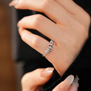 Detailed close-up showing a sparkling zircon geometric rotating ring on a finger