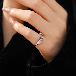 Close-up of minimalist silver ring with sparkling zircon-studded movable beads on a hand