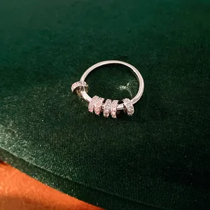 Close-up detail of a silver ring featuring pink and clear zircon geometric sliding charms