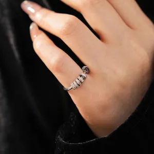Macro detail of a minimalist silver ring featuring sparkling zirconia movable beads.