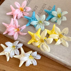 Detailed view of colorful starfish and flower hair clips featuring sparkling rhinestones
