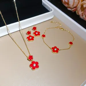 Detailed view of red flower pendant jewelry set with gold plating and zircons
