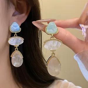 Détail macro de boucles d'oreilles vintage en résine de style palais avec cadre doré